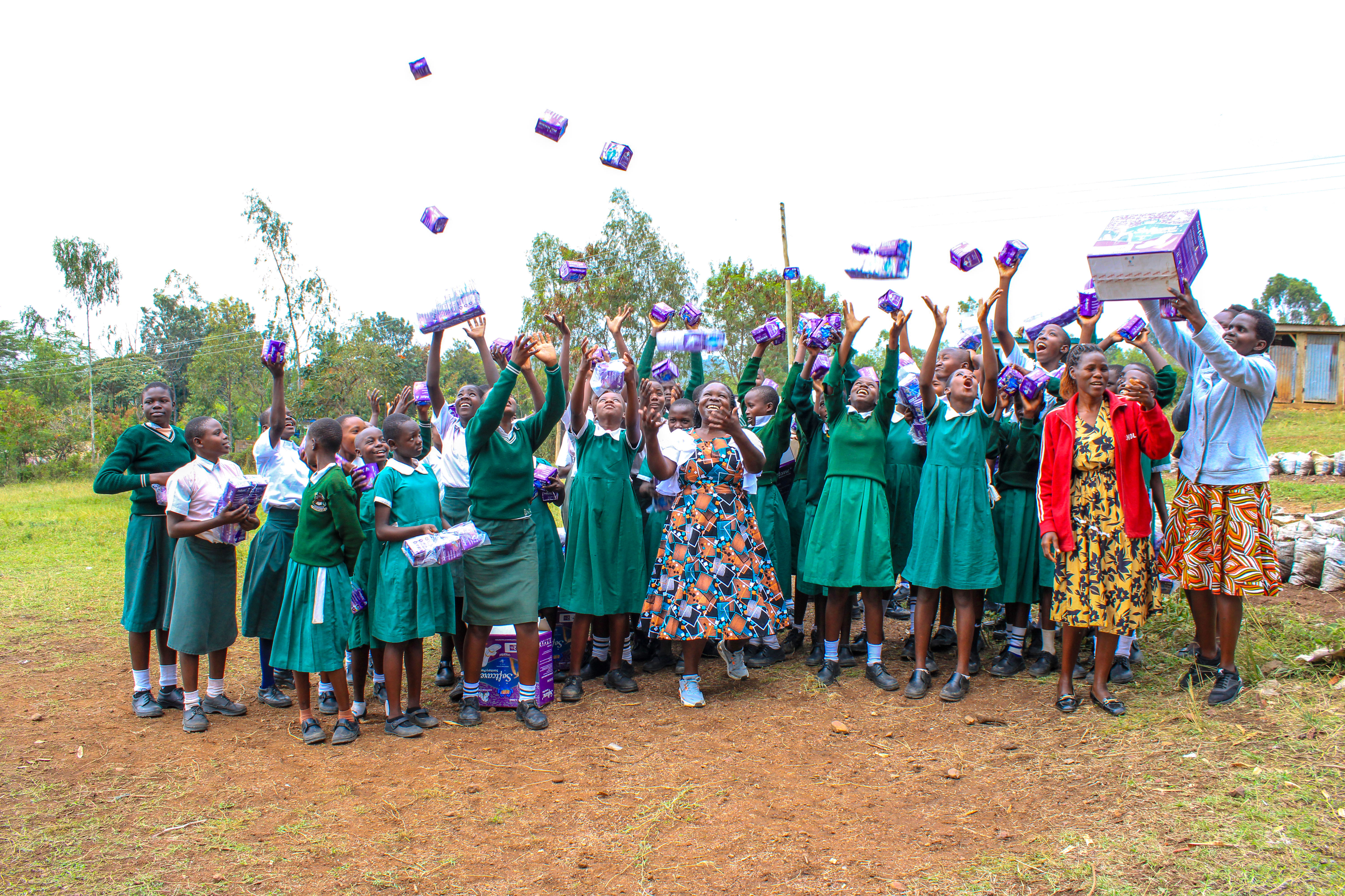SIC staff distributing sanitary pads to teenage girls at Angiro