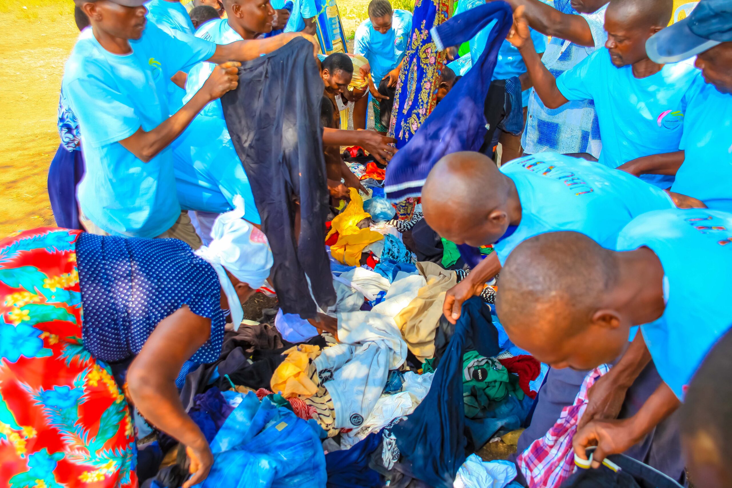 Men receiving donated clothes from the Sustainable Innovation Centre